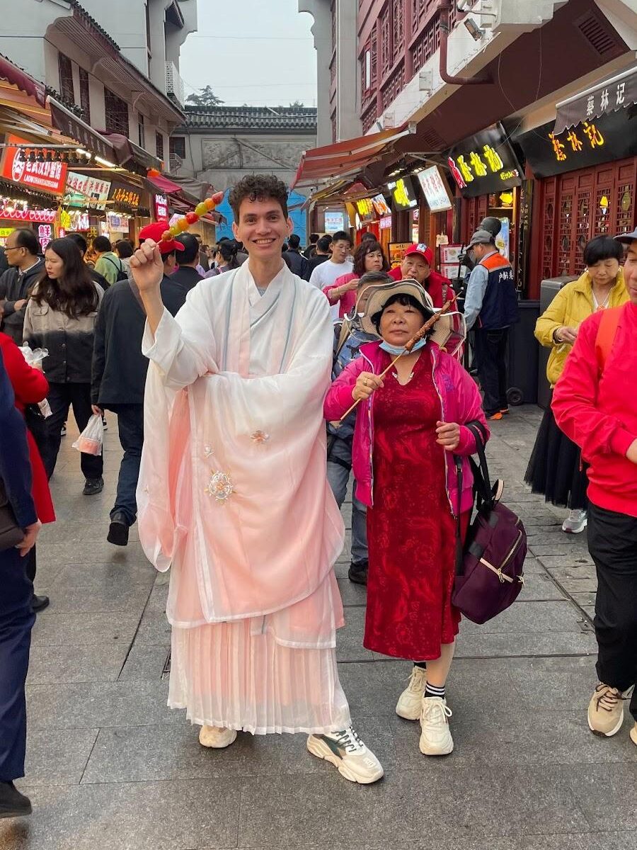 Prof Ju, do Clube de Chinês, vestindo hanfu e acompanhado de uma senhora vestindo um  qipao.